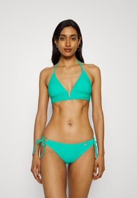 Turkio spalvos bikini maudymosi kostiumėlis, turintis trikampį viršų su plonomis petnešėlėmis ir V formos iškirpte, papildytas šoninėmis maudymosi kelnaitėmis, susirišamomis. Lygus paviršius.