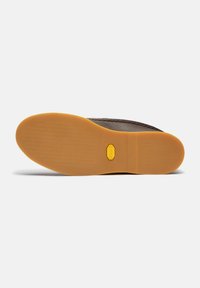 Pantof brown din piele, cu o talpă din cauciuc care prezintă un model texturat și un logo galben pe talpă. Designul este elegant și minimal.