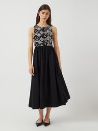 Μαύρο αμάνικο φόρεμα με κεντημένο μπούστο με λουλουδάτα σχέδια, υφασμάτινη υφή και φούστα που φτάνει μέχρι το γόνατο.