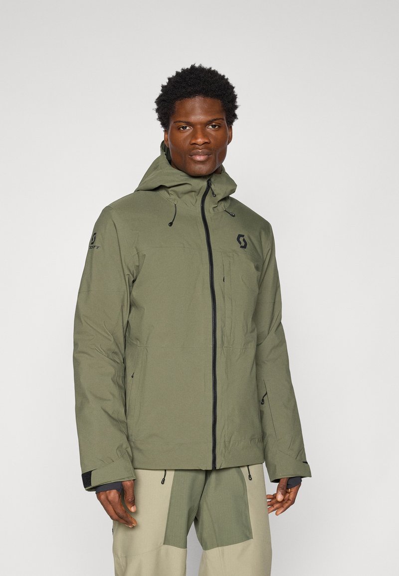 Olivgrüne, wasserdichte Jacke mit Kapuze, Reißverschluss, verstellbaren Bündchen und Logo auf der Brust. Hergestellt aus strapazierfähigem, strukturiertem Stoff.