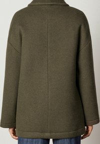 Abrigo de mezcla de lana de color verde oliva con un corte relajado, amplio cuello y hombros caídos. Presenta un acabado de costura limpio y puños texturizados.