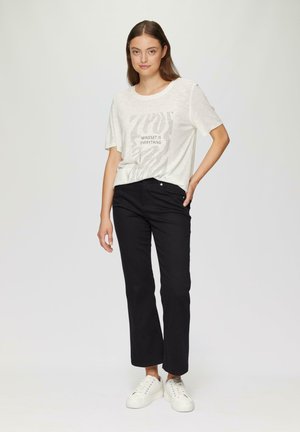 Light gray short-sleeve T-shirt with a printed design and text, paired with black straight-leg pants and white sneakers.