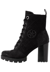 Stivale alla caviglia nero con upper in suede trapuntato, punta tonda, cappuccio decorato e tacco a blocco testurizzato; presenta un logo decorativo e lacci.