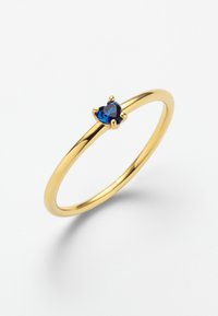 Goldring mit einem glatten, dünnen Band, das einen herzförmigen blauen Edelstein trägt, der von vier Krappen gehalten wird und eine polierte Oberfläche aufweist.