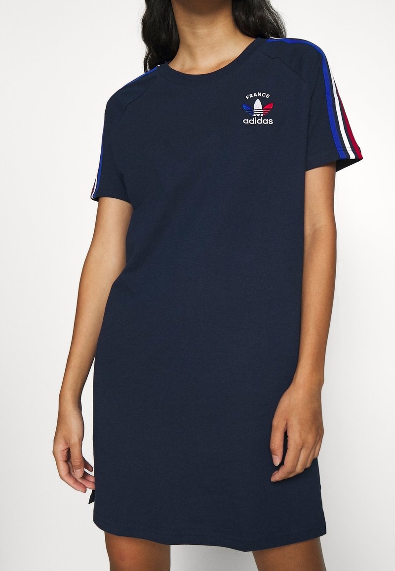 Robe en coton bleu marine à manches courtes, ornée d'une broderie "France" et du logo adidas, avec des accents rayés aux épaules en rouge, blanc et bleu.