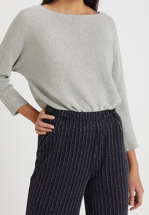 Top grigio chiaro a coste con scollatura ampia, abbinato a pantaloni a righe blu scuro con dettagli dorati e vita elastica.