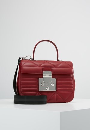 Czerwona pikowana skórzana torba na ramię z górnym uchwytem, srebrnym metalowym zapięciem oraz odpinanym czarnym paskiem na ramię, prezentowana na białej powierzchni.