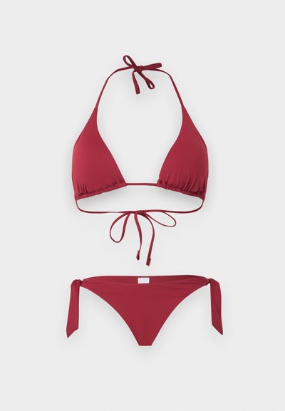 Κόκκινο μπικίνι σετ με τριγωνικό σχέδιο, λαιμόκοψη halter και δέσιμο στο λαιμό, την πλάτη και τις πλευρές του κάτω μέρους, σε απλό φωτεινό φόντο.