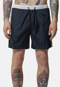 Costumi da bagno navy realizzati in un materiale leggero e testurizzato, con vita elasticizzata, chiusura con cordoncino e dettagli laterali bianchi a contrasto.