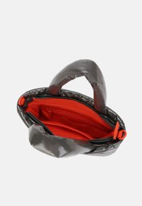 Borsa trapuntata grigia con finitura lucida, dotata di interno rosso e tasche con cerniera. Due manici arrotondati per un trasporto facile.