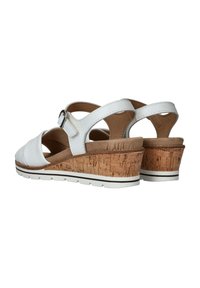 Sandalias de cuña de cuero blanco con tacón de corcho, correa ajustable, plantilla suave y parte superior texturizada. Presenta una suela blanca plana con acentos negros.