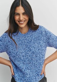 Short-sleeve, knitted sweater in varying shades of blue, featuring a round neckline and an open, textured stitch design.