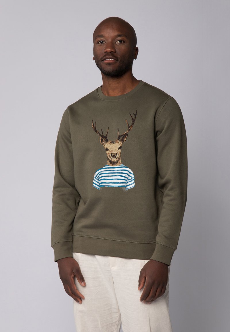 Grüne Sweatshirt mit einem Hirsch mit Geweih, der ein blau-weiß gestreiftes Shirt trägt, vor einem hellgrauen Hintergrund präsentiert.