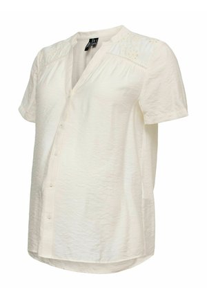 Lysecremefarvet kortærmet bluse med subtil blomsterbroderi på skuldrene, knaplukning foran og blødt, let tekstureret stof.