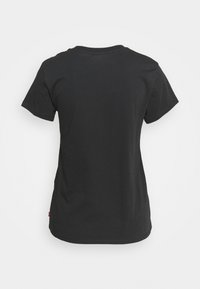 T-shirt noir à manches courtes et col rond présenté de dos, avec un ourlet droit et une petite étiquette latérale en bas à gauche.