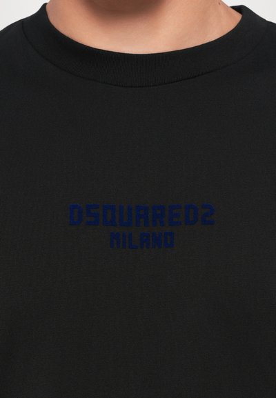 Must musta T-särk, millel on ümar kaelus, tehtud puuvillast, sinise tikandiga tekst "DSQUARED2 MILANO" rinnal. Sile tekstuur, lühikesed varrukad.