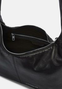Borsa a spalla in pelle nera con scomparto principale aperto che mostra una tasca interna con zip e dettagli in cerniera silver.