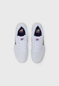 Zapatillas deportivas blancas con un diseño de malla, interior en contraste de color marino y acentos de logotipo prominentes en rojo y negro en los lados y la lengua.