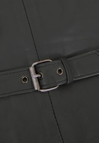 Schwarzes Lederarmband mit Metallschließe und zwei Metallösen auf einer schwarzen Ledermatte mit sichtbaren Nähten.