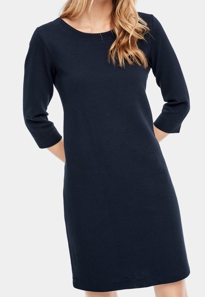 Navy blue sukienka z 3/4 rękawami, okrągłym dekoltem, wykonana z teksturowanej tkaniny. Unikata długość do kolan, minimalne detale, luźny krój.