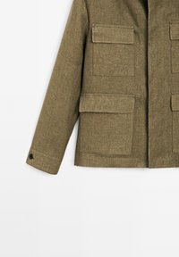 Olive green jacket with a textured fabric, featuring four front pockets, a high collar, and a button-adjustable sleeve cuff.