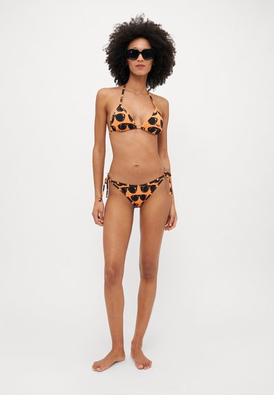Bikini set in orange with black sunglasses print; triangle top with halter straps, matching tie-side bottoms. Smooth fabric, minimal hardware.