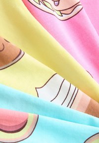 Värvikas puuvillane kangas, millel on multikatoidumustrid: roosa hamburgeriga, kollane sjukoogikesega ja sinine magustoiduga, kihiti üksteise peal.