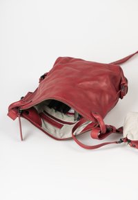 Rode leren schoudertas met een ritssluiting, voorzien van een gestructureerde buitenkant en gestreepte stofvoering. Inclusief een binnenzak en verstelbare schouderband.