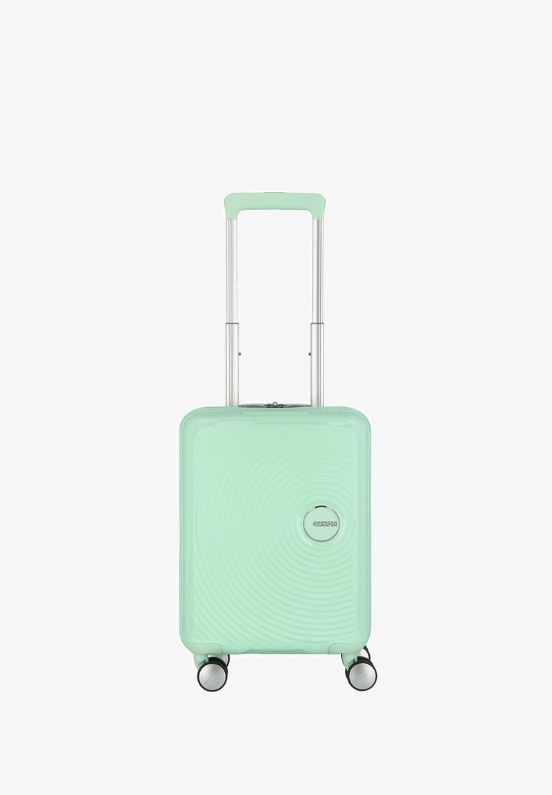 Valigia rigida verde menta con un motivo a onde, manico retrattile e quattro ruote per la mobilità. Presenta un logo sul fronte.