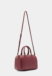 Burgunderfarbene Leder-Handtasche mit strukturiertem Design, zwei oberen Griffen und einem abnehmbaren Schultergurt. Verfügt über Akzente aus goldfarbenem Metall.