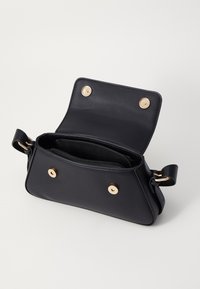 Borsa in pelle nera con forma strutturata, caratterizzata da bottoni in metallo dorato, design aperto e due scomparti interni con zip.