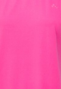 Jasnoróżowa koszula z krótkim rękawem, wykonana z gładkiego, lekkiego materiału, o prostym fasonie, bez widocznych wzorów czy ozdób.