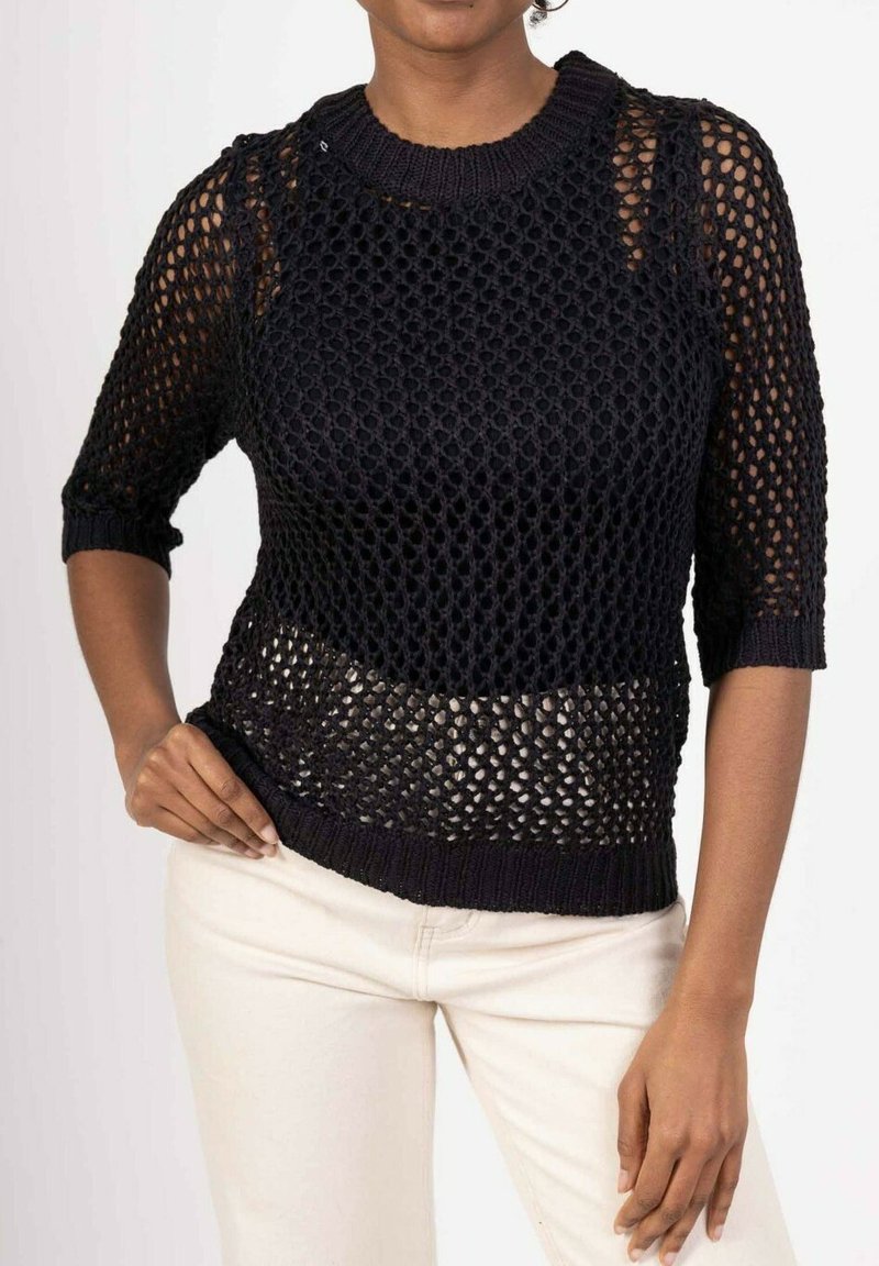 Pull noir en tricot avec un design en maille ouverte et lâche, des manches courtes, un col rond et une taille côtelée. Léger et texturé.