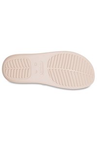 Semelle de chaussure en caoutchouc rose clair avec une surface texturée et à motifs, comportant des rainures pour l'adhérence et un logo de marque au centre.