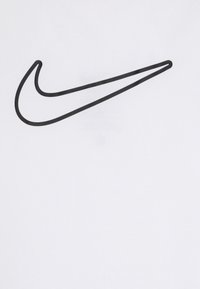 T-shirt blanc arborant un grand logo Nike swoosh noir, imprimé dans un design audacieux sur le tissu lisse et uni.