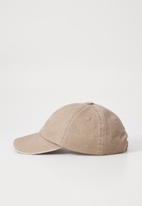 Beige cotton baseball cap with a curved brim, six-panel construction, and subtle stitched accents. Text printed on the front in light color.