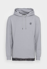 Sudadera con capucha de color gris claro con cordones, pequeño logo negro en el pecho y dobladillo negro con el nombre de la marca "SIKSILK" repetido.