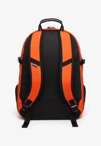 Czarny i pomarańczowy plecak z wyściełanymi szelkami, uchwytem na górze i regulowanymi klamrami bocznymi. Teksturowany materiał w kontrastujących kolorach.