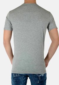 Grijze t-shirt met korte mouwen gemaakt van zacht materiaal. De achterkant heeft een klassieke ronde hals en een getailleerd ontwerp. Draag het met blauwe jeans.