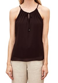 Ciemnobrązowy top bez rękawów z zebranym dekoltem, regulowanym sznurkiem i gładką fakturą. W zestawie z jasnobeżowymi spodniami.