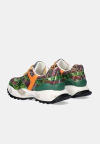 Zapatillas de deporte bajas con tela de purpurina multicolor, acentos en verde y naranja, suelas blancas gruesas y banda de rodadura negra, mostradas desde ángulos trasero y lateral.