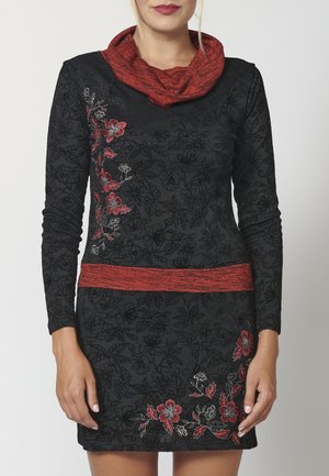 Schwarzes Langarmkleid mit roten und silbernen Blumenstickereien, einem roten strukturierten Schalkragen und einem passenden roten Taillenbund.