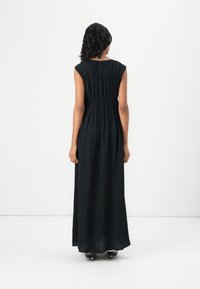Black, sleeveless maxi dress with pleated texture, cinched waist, and a flowing silhouette. Smooth fabric extends to the ankles.