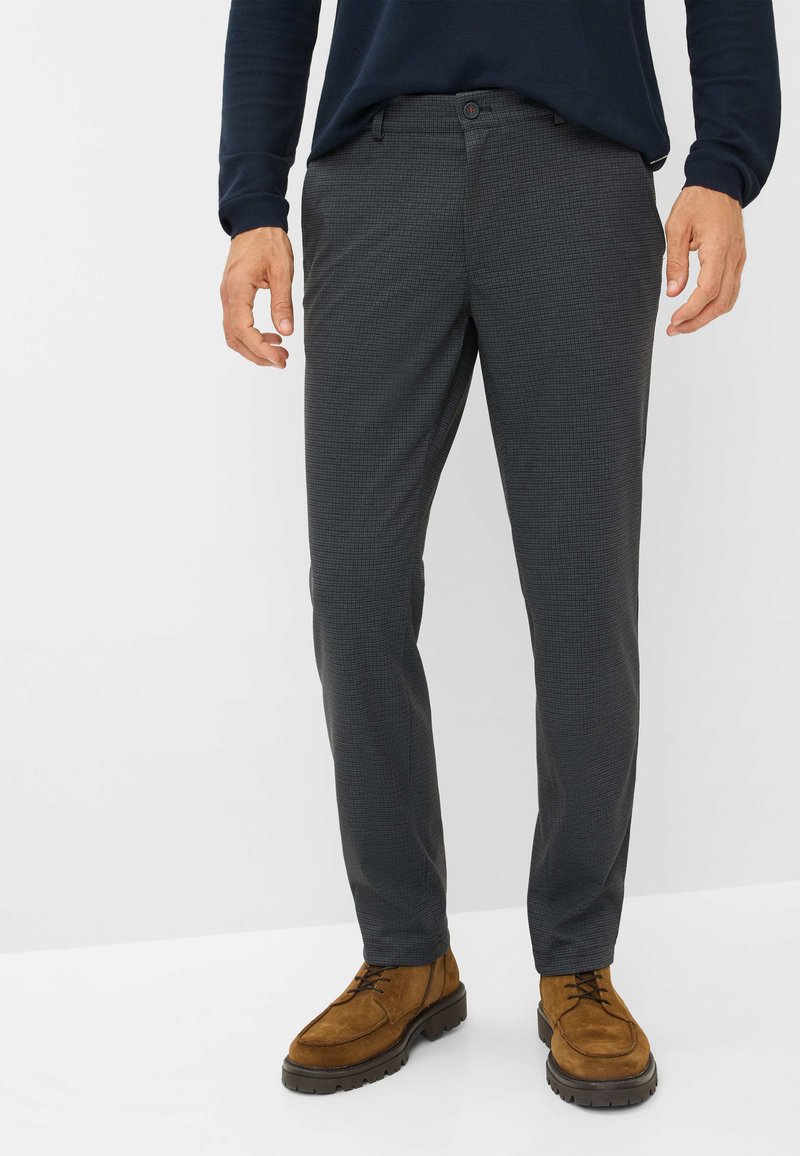 Grijze geblokte broek met een rechte snit, gemaakt van geweven stof, met zijzakken en een knoopsluiting. Gecombineerd met bruine suède schoenen.