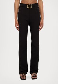 Pantaloni neri su misura realizzati in un tessuto morbido, con una cintura larga dotata di una fibbia in oro texturizzato e un design a gamba dritta.