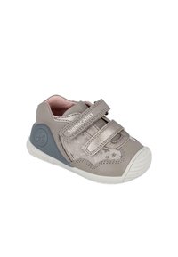 Zapato de cuero gris para niños pequeños con correas de Velcro, forro rosa y acentos en forma de estrella plateada texturizada. Presenta una suela de goma blanca y soporte en el talón gris.