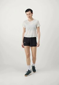 Hvit cropped T-skjorte, svarte atletiske shorts, hvite ankelstrømper og grønne joggesko. Enkel design, lett materiale, egnet for trening.