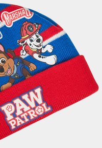 Cappello beanie azzurro in maglia con personaggi canini animati su una banda rossa. Include un logo "PAW PATROL" e dettagli a righe.