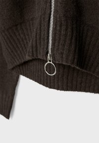 Brauner Wollpullover-Fragment mit gerippter Textur, schrägem Saum und einem silbernen Reißverschluss mit rundem Ziehband.