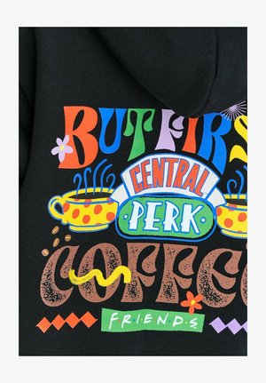 Čierna látka s farebným textom: "ALE NAJPRV KÁVA" a "CENTRAL PERK", obsahujúca šálky kávy, kvety a dekoratívne akcenty.